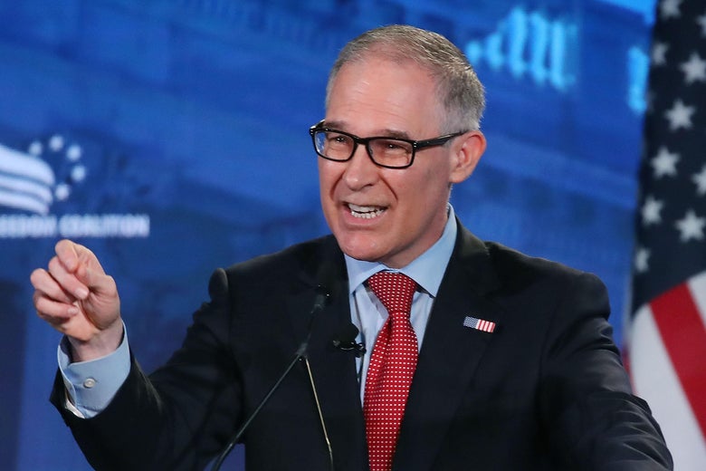 Pruitt gestures as he speaks behind of a podium in front of an American flag